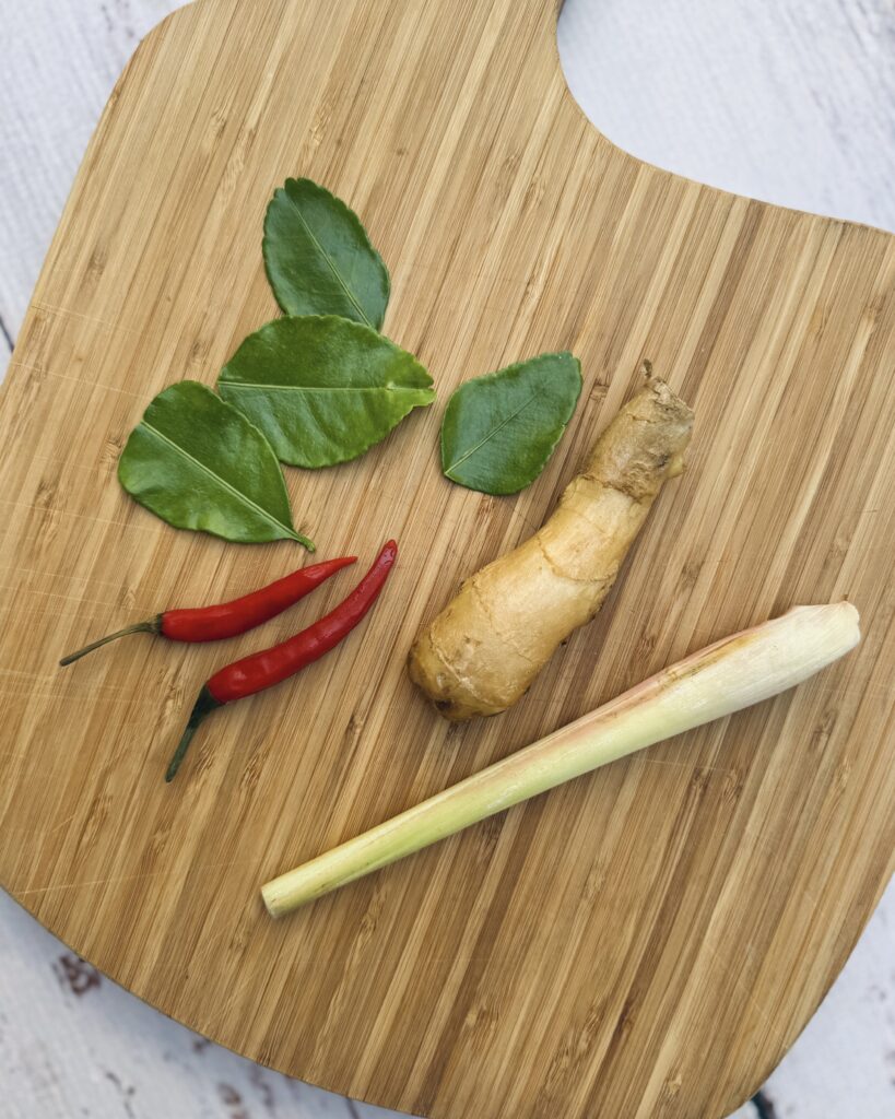 a board with thai aromatics - makrut lime, rec chili, lemongrass and ginger